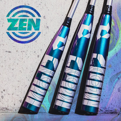 Three metallic blue and purple 2026 DeMarini ZEN Oil Slick (-10) USSSA Baseball Bats with bold white graphics lean against a concrete wall, beside a circular “ZEN” logo, highlighting their advanced Dark Matter Composite barrel design.
