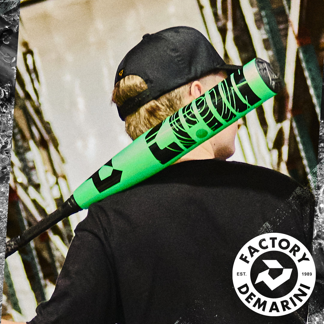 A person in a backwards black cap carries a bright green 2026 DeMarini ZEN (-8) 2 3/4" USSSA Baseball Bat (WBD2592010) with a composite barrel over their shoulder. The DeMarini logo appears in the bottom right corner.