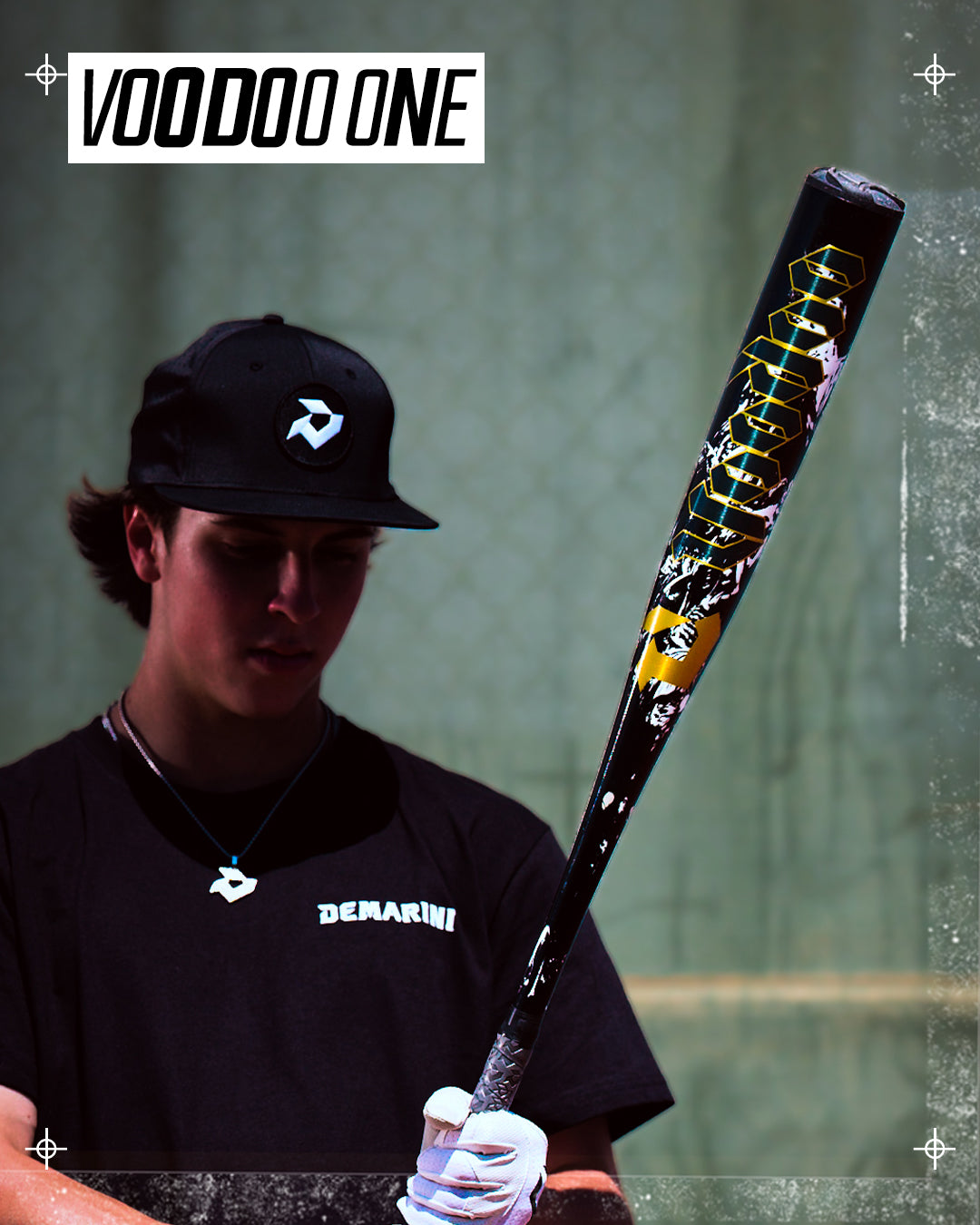 A baseball player in a black cap and shirt holds the 2027 DeMarini Voodoo One (-3) BBCOR Baseball Bat (WBD2705010), featuring an X14 Alloy Barrel and bold "VOODOO ONE" text on the bat's upper left.
