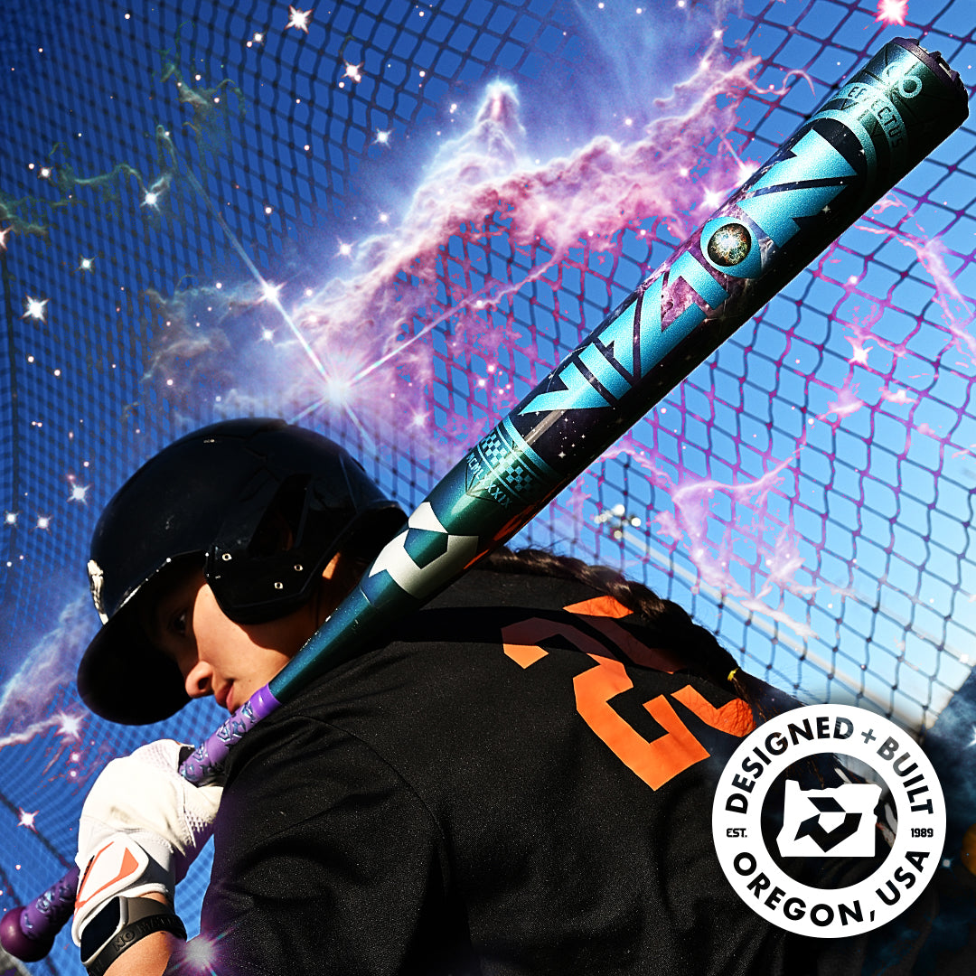A softball player in a black helmet and jersey holds the DeMarini 2027 Vizion (-8) Fastpitch Softball Bat (WBD2730010) over their shoulder by a chain-link fence, with cosmic effects and a Designed + Built in Oregon, USA logo shown.