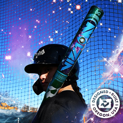 A softball player in a black helmet holds the DeMarini 2027 Vizion (-8) Fastpitch Softball Bat (WBD2730010) over their shoulder, standing before a blue net with a cosmic effect. A badge reads “Designed + Built in Oregon, USA.”.