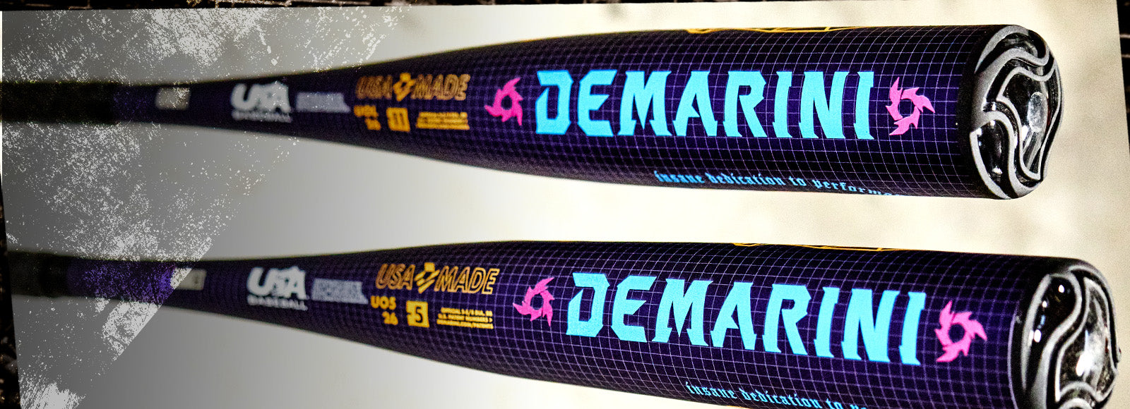 Two black DeMarini baseball bats with bright blue and pink logo text and yellow labeling on a grid-patterned background, shown from the barrel end, positioned parallel to each other.