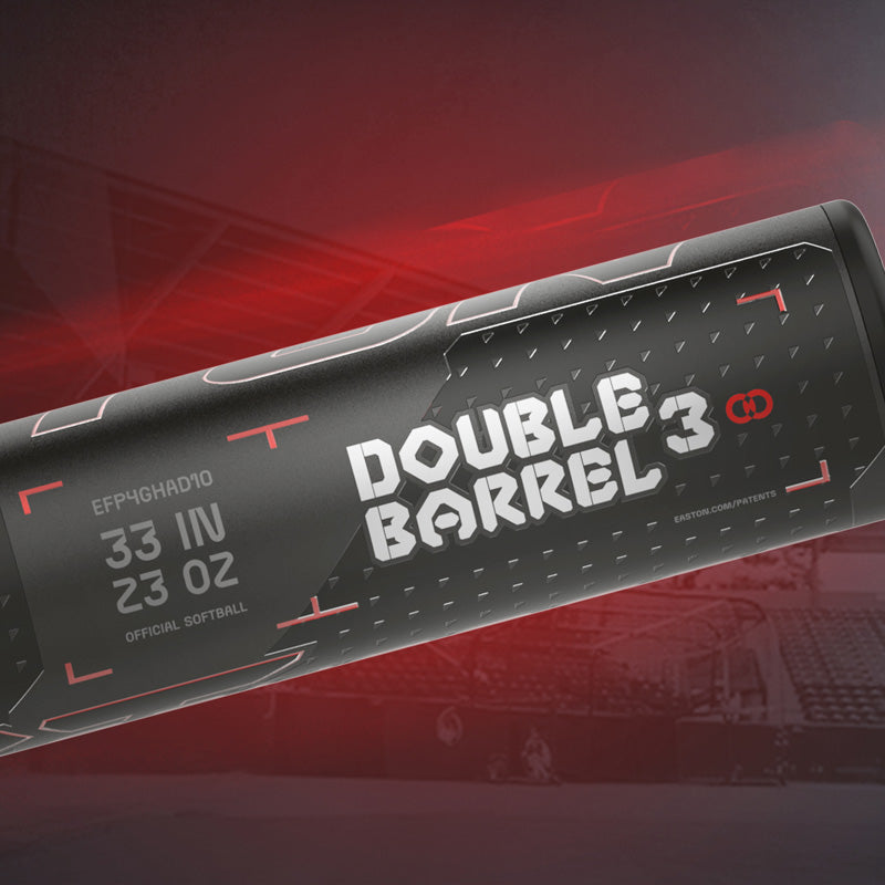 Close-up of a black softball bat with white text that reads Double Barrel 3. Red accents and a stadium background with a glowing red hue are visible, giving a dynamic and sporty feel to the image.