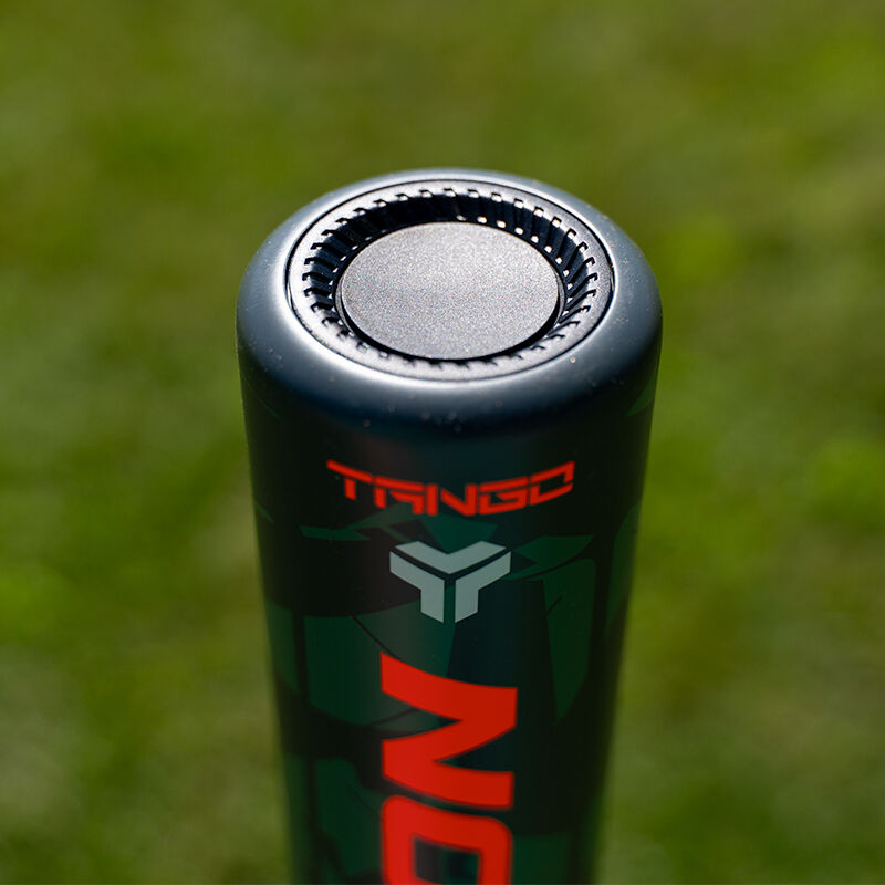 Close-up of the end cap on a 2025 Easton Tango (-8) 2 5/8" USA Baseball Bat (EUS5TNG8) by Easton, showing the TANGO name and geometric logo, with a blurred grassy background.