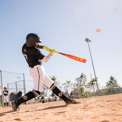 A person swinging the 2025 Easton Hype Fire JBB (-10) 2 3/4" USSSA Baseball Bat (EJB5HYP10), featuring advanced Thermo-Composite Technology.