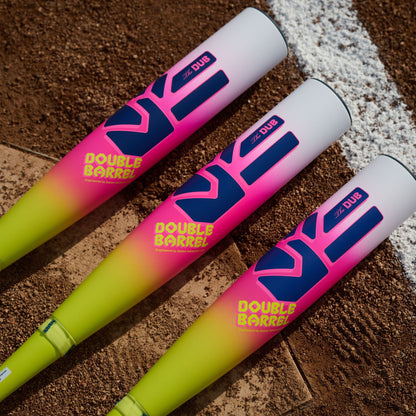 Three vibrant Easton 2026 Dub (-10) USSSA bats with two-piece composite design and eye-catching Double Barrel graphics rest side by side on the field, featuring white tops and pink-to-yellow-green gradient barrels.