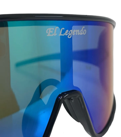 Close-up of Akadema El Legendo Sunglasses (ELLEGENDO) with blue mirrored UV400 lenses, "Akadema" branding on the lens, and reflections on the black frame and nose piece.