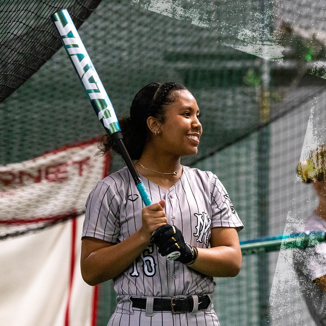 A woman grips the 2026 DeMarini Lotus (-11) Fastpitch Softball Bat (WBD2605010 DEMO), poised to swing with confidence.