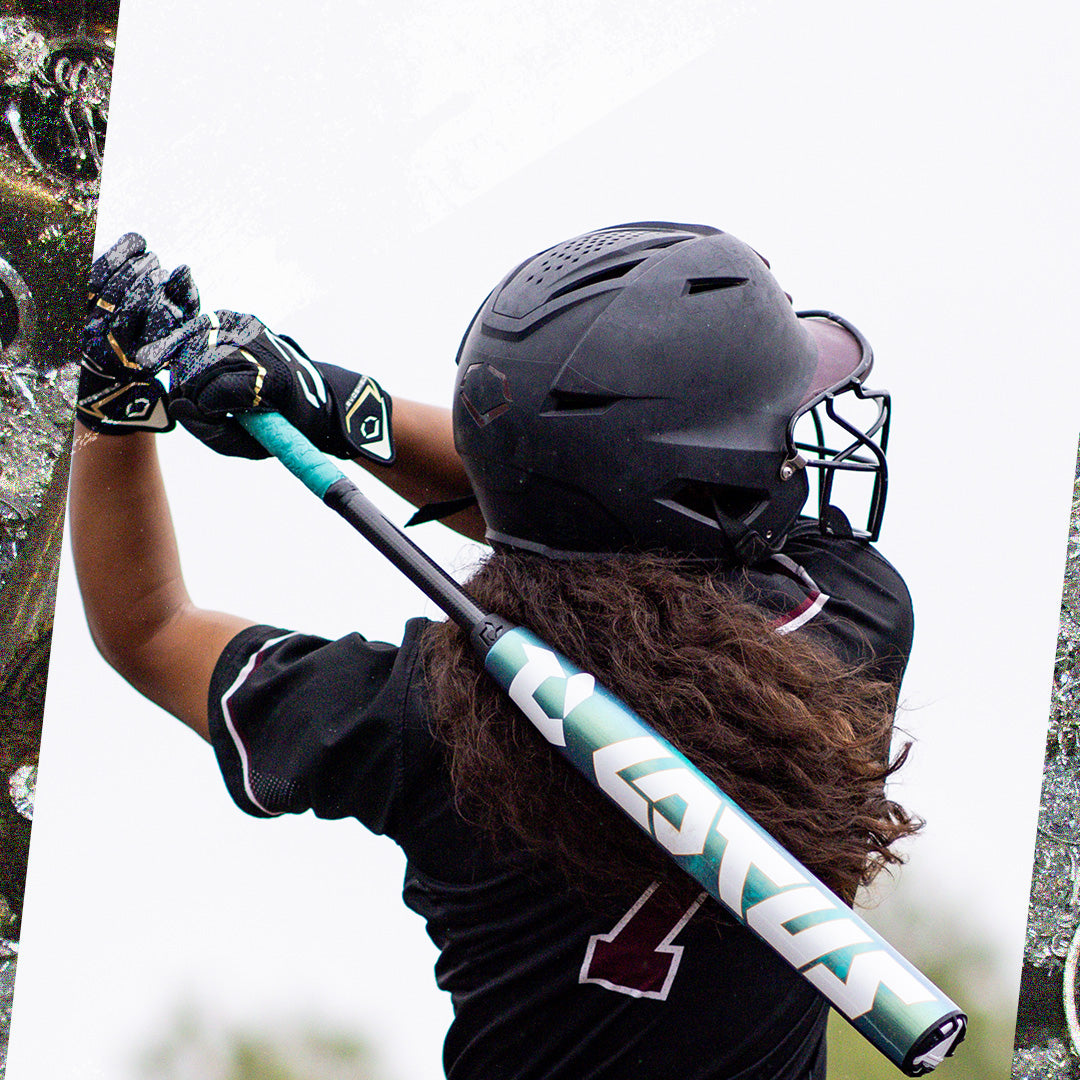 A softball player in black swings a teal and white 2026 DeMarini Lotus (-11) Fastpitch Softball Bat (WBD2605010), viewed from behind, as long hair flows from under the helmet while connecting with the gapped wall barrel.