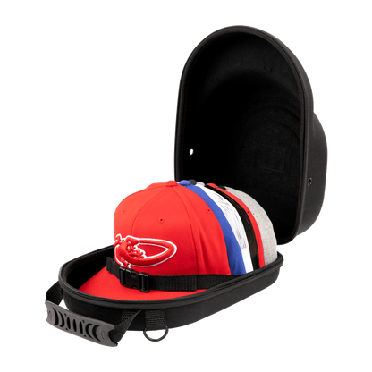 The Lizard Skins Hat Guardian: HATGD100 is a black, crush-proof hat case with a handle and interior strap, shown open to display several colorful baseball caps inside. The protective case is set against a plain background.