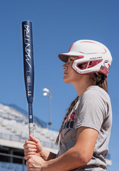 A woman holding a 2025 Rawlings Mantra (-9) Fastpitch Softball Bat: RFP4M9 (DEMO) by Rawlings.