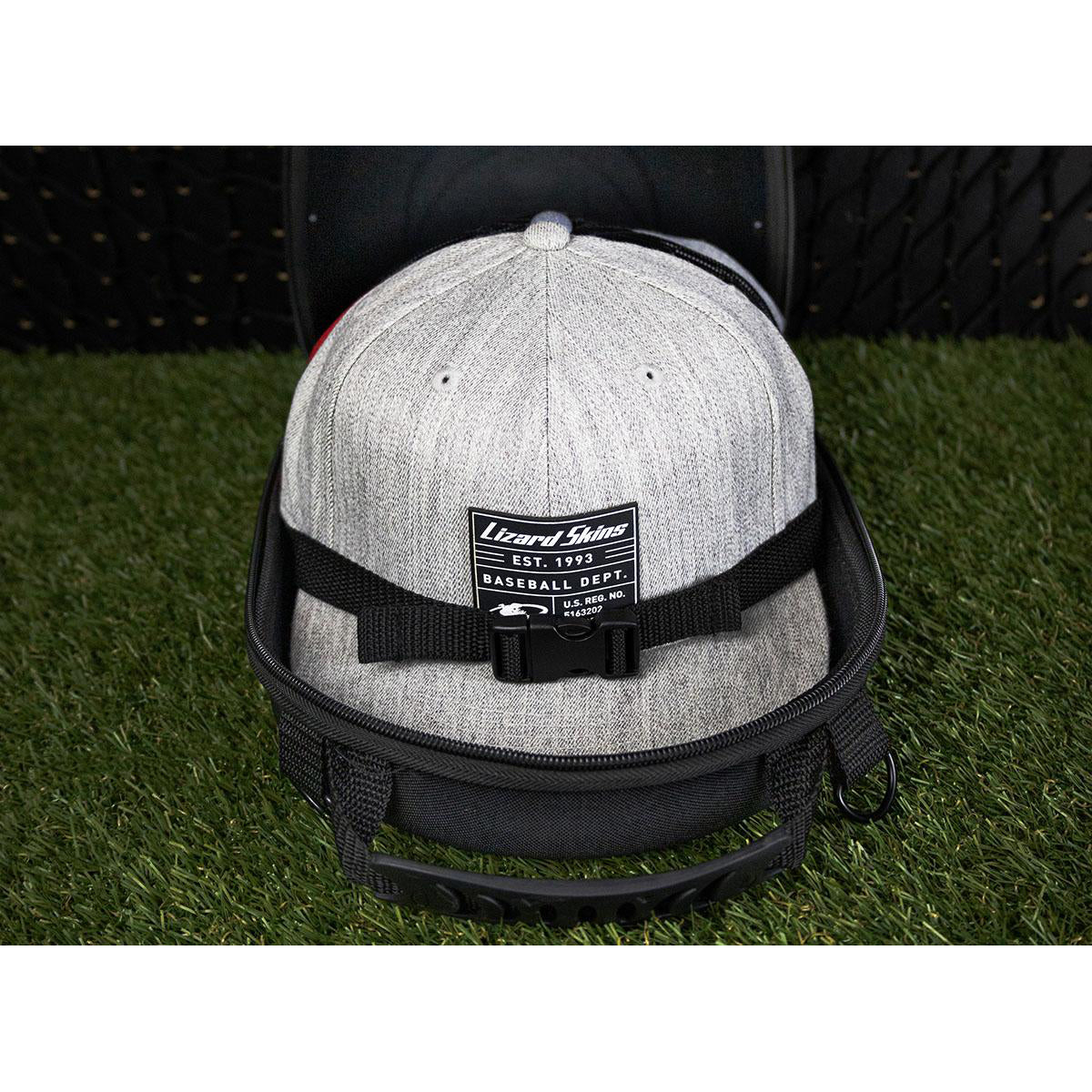 The Lizard Skins Hat Guardian: HATGD100 is a crush-proof case, shown with a gray cap featuring a black strap and Lizard Skins Baseball Dept. EST. 1992 patch, keeping your hat secure and protected on the go.