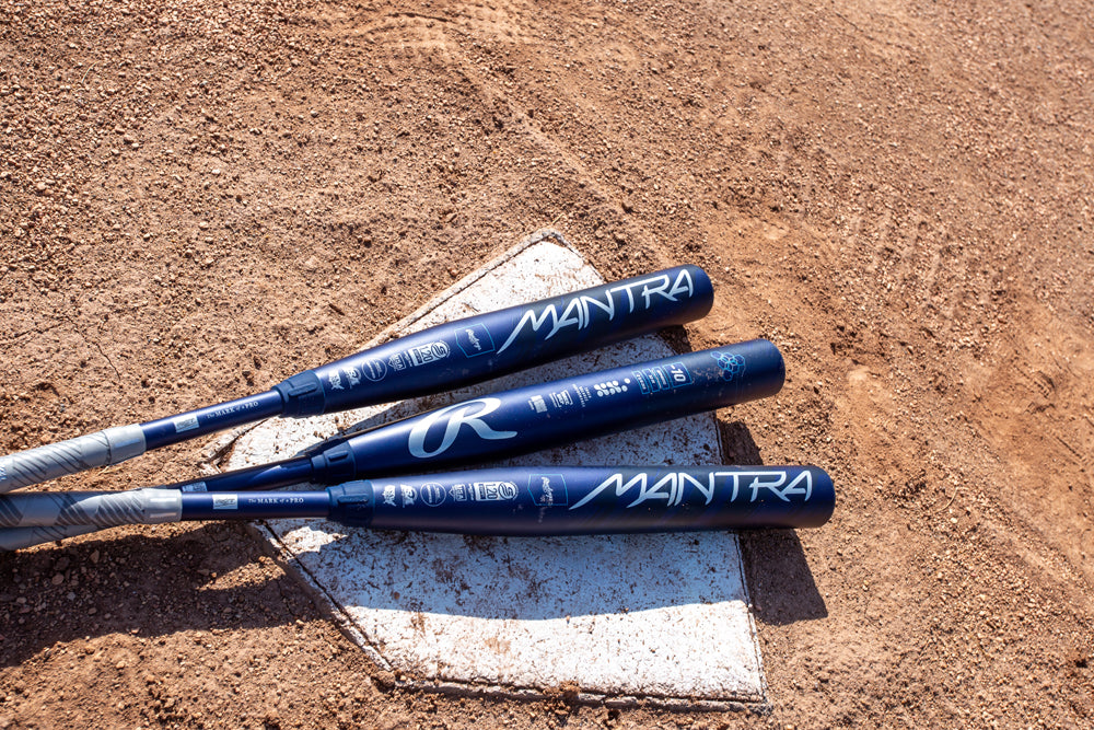 A 2025 Rawlings Mantra (-9) Fastpitch Softball Bat: RFP4M9 (DEMO) by Rawlings rests on the dirt field, ready for the next big hit.