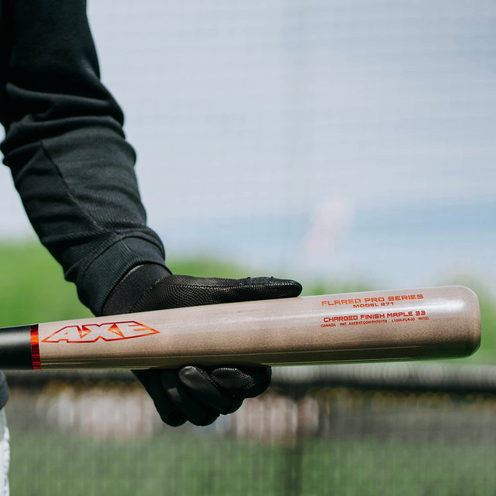 A person holding an AXE Flared Pro Series Maple Wood Baseball Bat (L124K-FLR) by AXE, featuring a pro flared handle.
