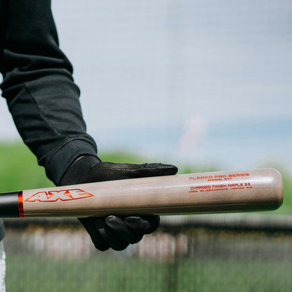 A person holding an AXE Flared Pro Series Maple Wood Baseball Bat (L124K-FLR) by AXE, featuring a pro flared handle.