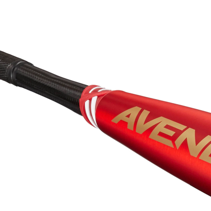Close-up of the flared handle and part of the barrel of a red 2023 AXE Avenge Pro Hybrid FLARED (-3) BBCOR Baseball Bat (L130K-FLR), with "AVEN" displayed in gold. The black AXE handle features a textured grip.