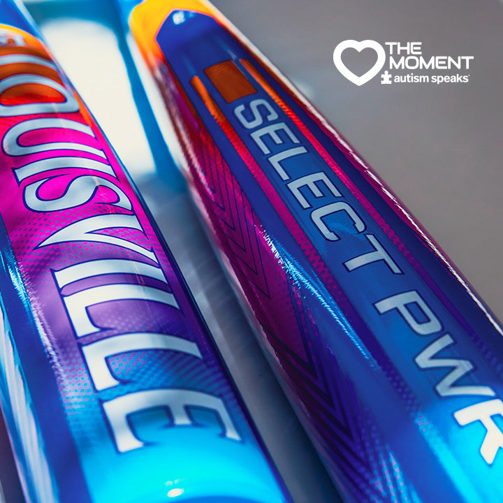 Close-up of two colorful 2026 Louisville Slugger Select PWR Love the Moment (-3) BBCOR Baseball Bats, with Autism Speaks and The Moment logos in the upper right corner.