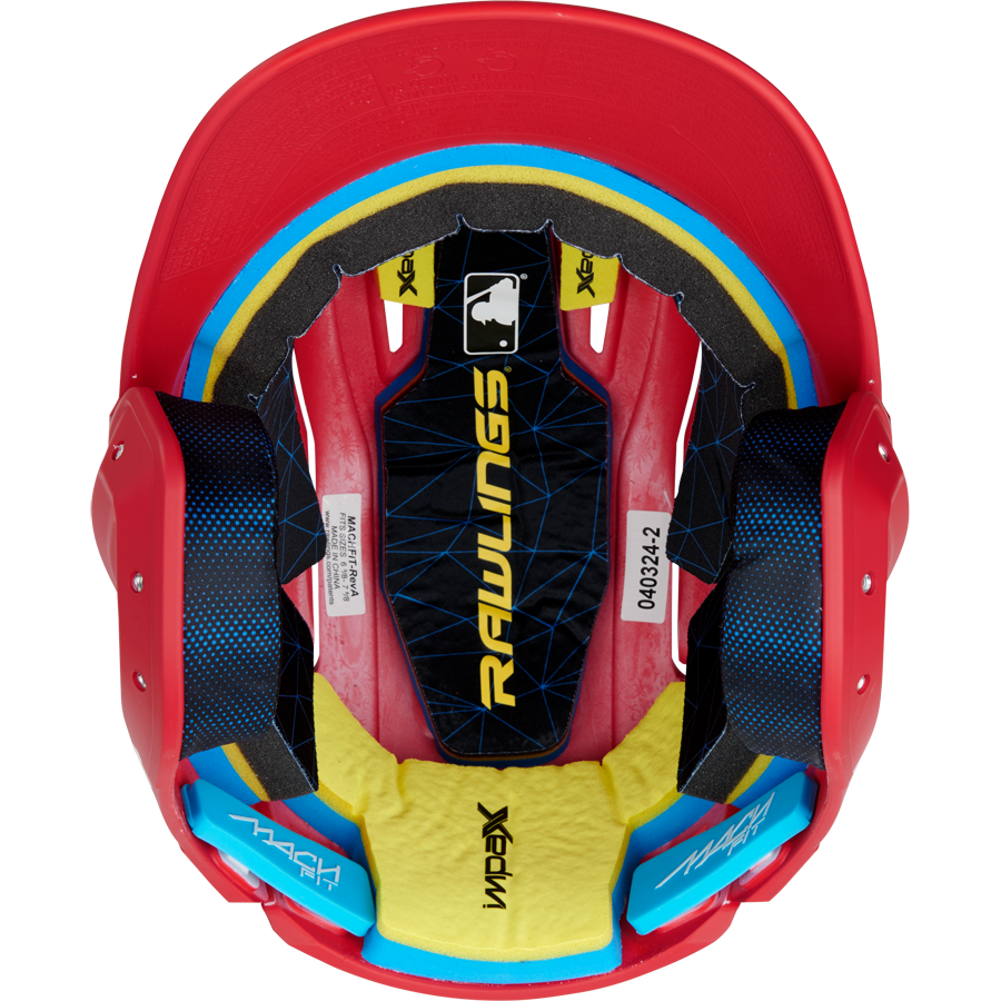 Top-down view of a red Rawlings Mach Fit Matte Batting Helmet (MACHFIT) with black, yellow, and blue IMPAX foam interior padding, white labels, and the MLB logo visible inside. Brand: Rawlings.