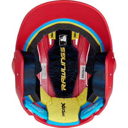 Top-down view of a red Rawlings Mach Fit Matte Batting Helmet (MACHFIT) with black, yellow, and blue IMPAX foam interior padding, white labels, and the MLB logo visible inside. Brand: Rawlings.