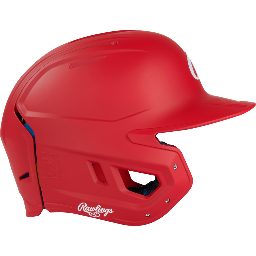 A Rawlings Mach Fit Matte Batting Helmet (MACHFIT) in bright red, featuring a face guard, ventilation holes, and IMPAX foam technology for protection, is shown from the side on a plain white background.