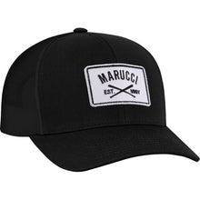 The Marucci Cross Patch Snapback Hat (MAHTTRPCS) is a black snapback with a curved brim, trucker mesh back, and a white front patch featuring the Marucci logo, two crossed bats, and "EST. MMIV" in black lettering.