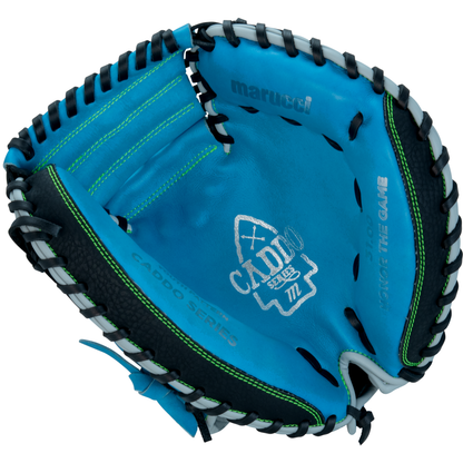The Marucci Caddo 31" Baseball Catcher's Mitt (MFG3CD310-SB/BK) features a blue and black design with green stitching, “Caddo Series” and “Honor The Game” inside, and is crafted from full-grain cowhide leather for durability.