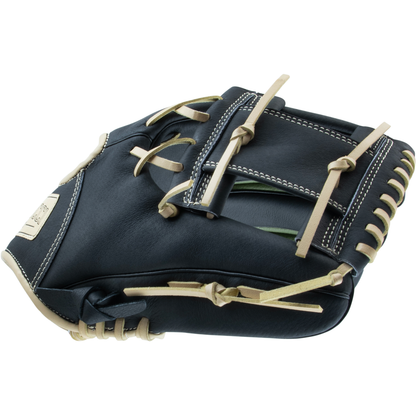 The Marucci Swift 11.5″ Baseball Glove (MFGSWFT115-OG/BK) is shown closed from an angle, featuring a sleek black design with tan laces, white stitching, and an I-Web pattern.