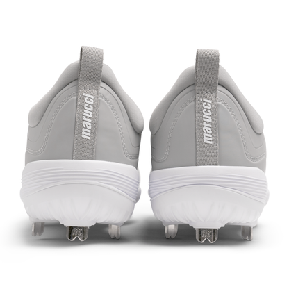 A pair of gray and white Marucci CFT Low Metal Cleats (MFWCTSL) shown from the back, featuring pull tabs labeled Marucci and metal spikes on white soles—designed for peak athletic performance.