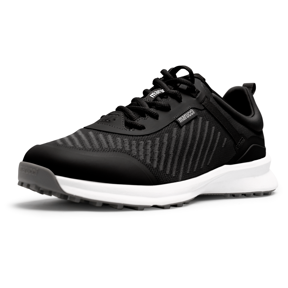 The Marucci CFT Turf Shoes: MFWCTT feature a black textured mesh upper, black laces, and a white cushioned sole with advanced cushioning and a traction rubber outsole, displayed angled on a white background.