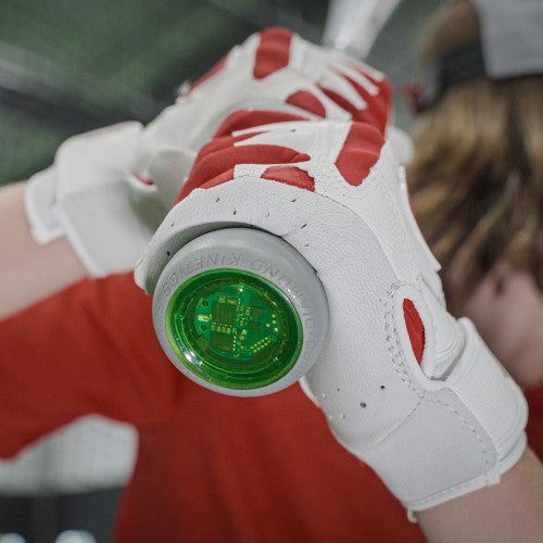 A person wearing white and red batting gloves grips a baseball bat with a green digital sensor attached to the knob, focusing on the bats end.