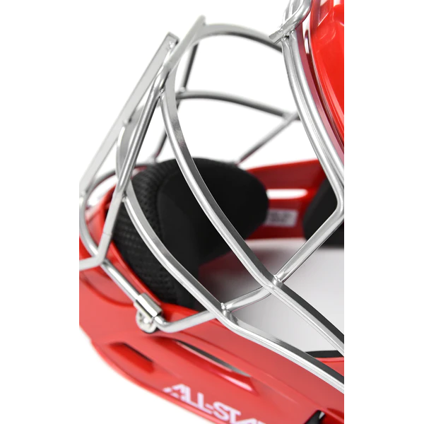 Close-up of a red catchers helmet with a silver metal face guard and black interior padding, showing part of the ALL-STAR brand logo on the helmet.