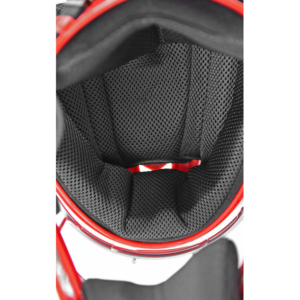 Close-up view of the interior padding of a red helmet, showing black, textured, mesh-like cushioning designed for comfort and protection.