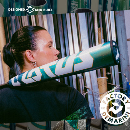 A woman with dark hair tied back holds a DeMarini 2026 Lotus (-11) Fastpitch Softball Bat (WBD2605010 DEMO) over her shoulder in front of metal pipes. DeMarini and Factory Designed and Built logos are overlaid on the image.
