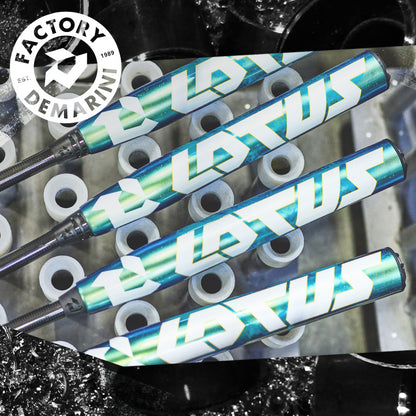 Three DeMarini Lotus (-11) Fastpitch Softball Bats, featuring teal and white graphics, are displayed diagonally across white plastic tubes. The DeMarini Factory logo in the top left highlights the brand’s innovation in softball bats.