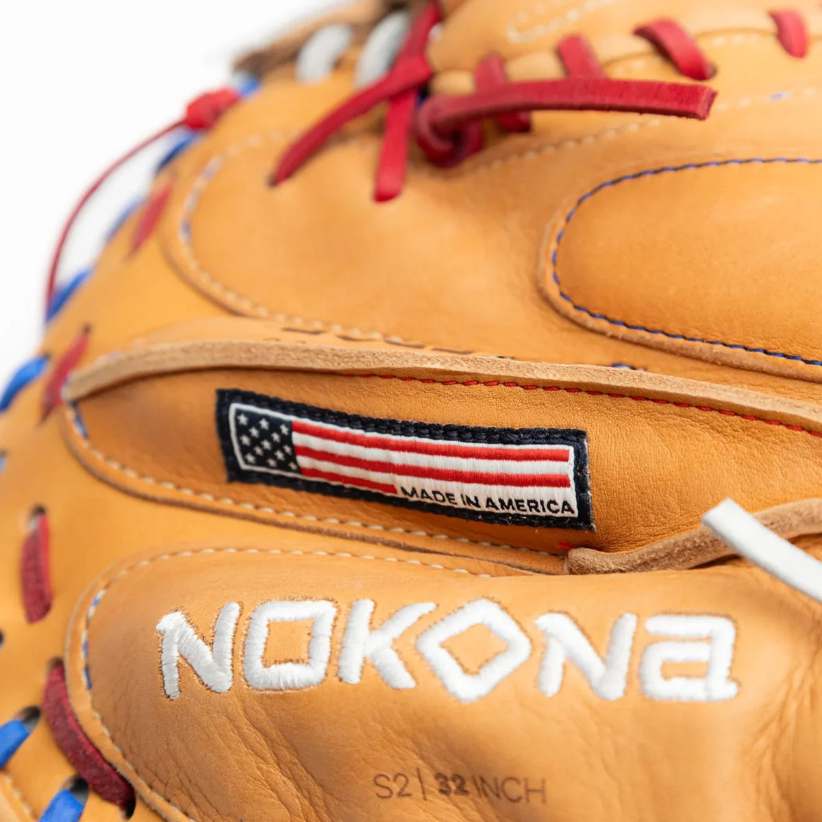 Tan Nokona S1 All-American 32″ Baseball Catcher’s Mitt: S1-EP2POP with red and blue lacing, featuring a label with an American flag and the text Made in America above the embossed brand name and size.