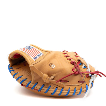 Tan Nokona S1 All-American 32″ Baseball Catcher’s Mitt: S1-EP2POP laced with blue, red, and white cords, featuring an American flag patch on the back.