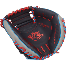 The Rawlings NXT 32.5″ Baseball Catcher’s Mitt (model NXTCM325UNG) showcases a stylish combination of black, gray, and red pro-soft leather with blue laces, highlighted by red-stitched Rawlings branding and text across the glove, all presented against a plain white background.