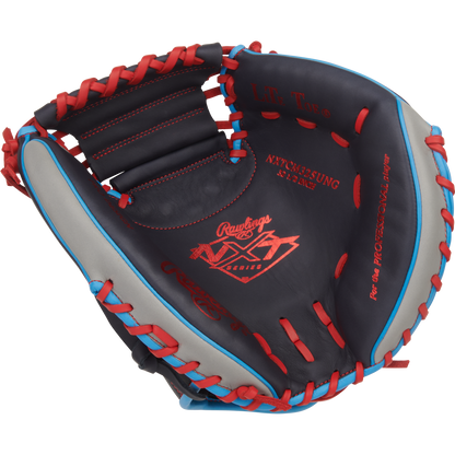 The Rawlings NXT 32.5″ Baseball Catcher’s Mitt (model NXTCM325UNG) showcases a stylish combination of black, gray, and red pro-soft leather with blue laces, highlighted by red-stitched Rawlings branding and text across the glove, all presented against a plain white background.