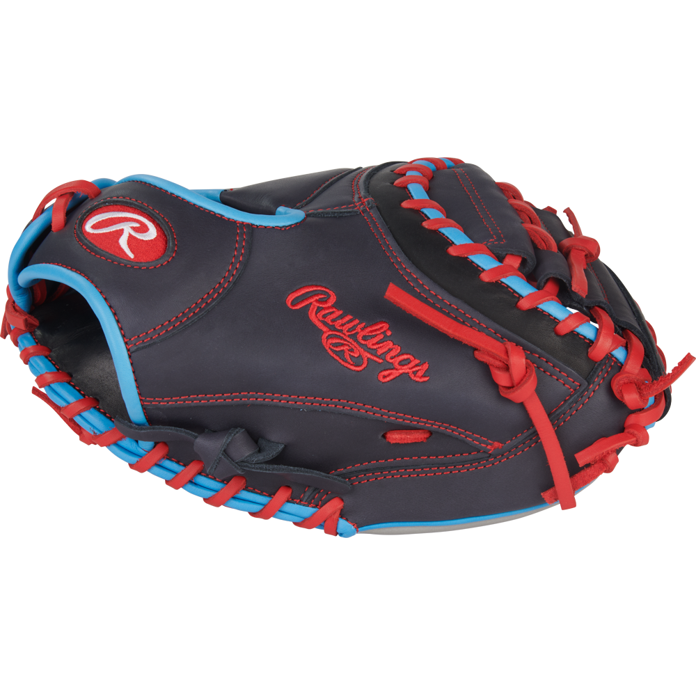 The Rawlings NXT 32.5″ Baseball Catcher’s Mitt (NXTCM325UNG) features a dark pro-soft leather design with striking red stitching and accents, complemented by blue trim and the iconic Rawlings logo embroidered in red on the side. Designed for youth players, this mitt delivers superior comfort and durability behind the plate.