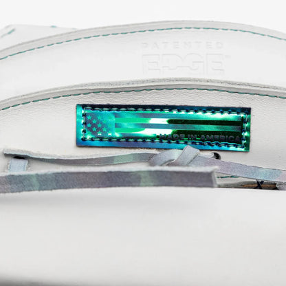 Close-up of a white AmericanKIP leather Nokona Halo 12.5″ Fastpitch Glove: WHT-EP1250H featuring a metallic green American flag label and the word EDGE embossed above it.