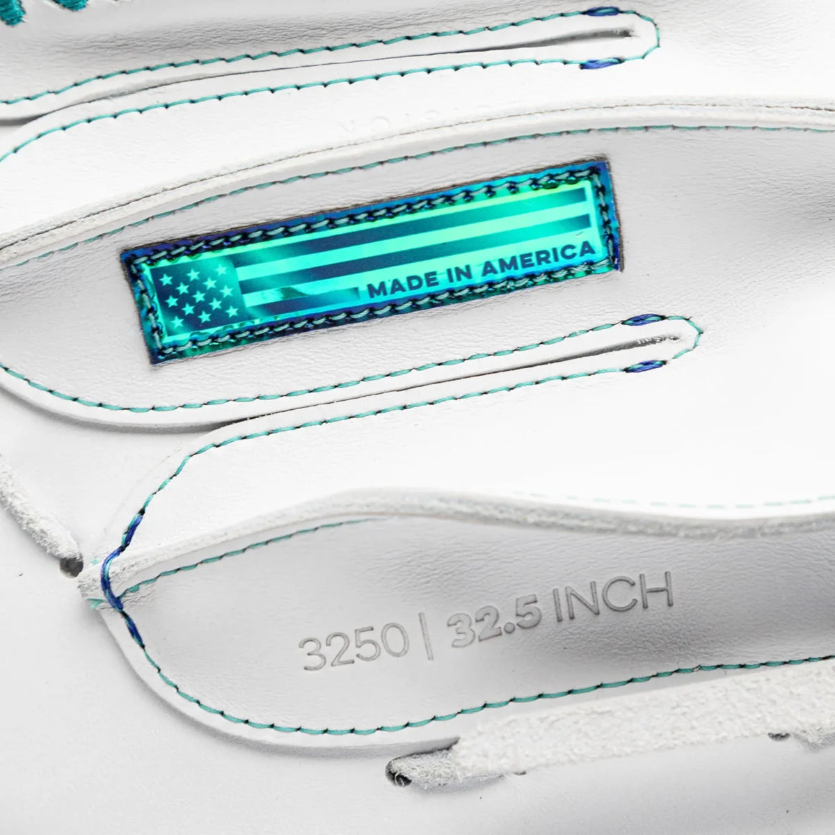 Close-up of a white leather Nokona Halo 32.5″ Fastpitch Catcher’s Mitt: WHT-EPV3250C featuring a rectangular holographic patch that reads MADE IN AMERICA with a star pattern, and an embossed stamp reading 3250 | 32.5 INCH.
