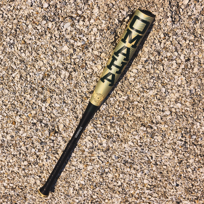 A 2026 Louisville Slugger Omaha (-3) BBCOR Baseball Bat (WBL4117010) by Louisville Slugger lies on the ground.