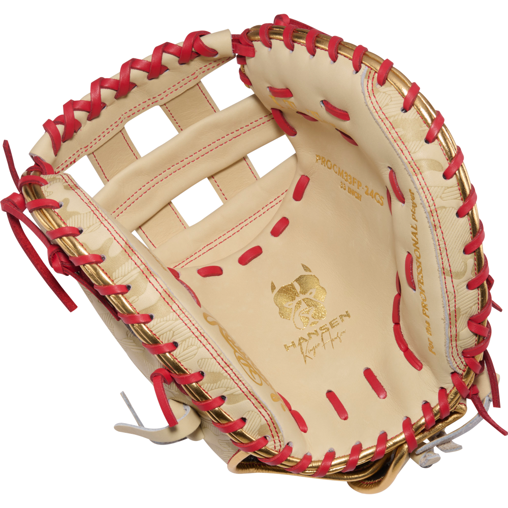 The Rawlings Heart of the Hide 33" Kinzie Hansen K9 Fastpitch Catcher's Mitt (PROCM33FP-24CS) features tan leather with red lacing, a bulldog logo, an open web design, and PROSPECT 2409 and WANTSEEN on the palm for top performance.