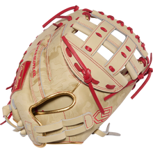 A tan and red Rawlings Heart of the Hide 33" Kinzie Hansen K9 Fastpitch Catcher's Mitt (PROCM33FP-24CS) with a woven web, red lacing, and embossed details is shown on a white background.