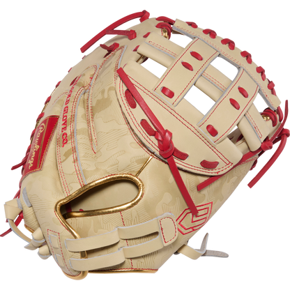 A tan and red Rawlings Heart of the Hide 33" Kinzie Hansen K9 Fastpitch Catcher's Mitt (PROCM33FP-24CS) with a woven web, red lacing, and embossed details is shown on a white background.