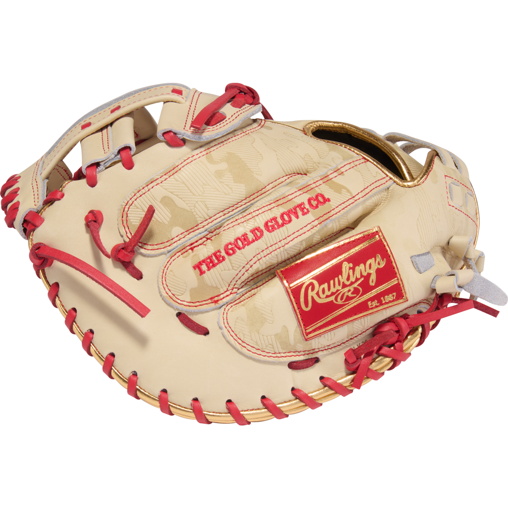 The Rawlings Heart of the Hide 33" Kinzie Hansen K9 Fastpitch Catcher's Mitt (PROCM33FP-24CS) features tan and red leather, red laces, gold accents, and THE GOLD GLOVE CO. and Rawlings logos, inspired by a classic catcher’s mitt design.