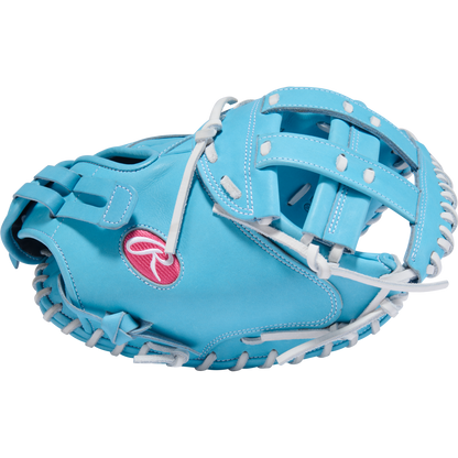 The Rawlings Heart of the Hide 34" Fastpitch Catcher's Mitt (PROCM34FP-24CBW) features light blue leather, white laces, and a pink and white Rawlings logo, displayed on a plain white background.