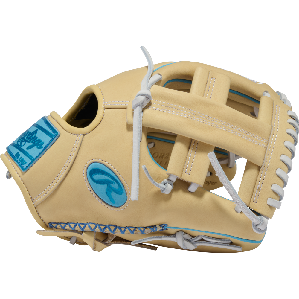 A side view of the Rawlings Heart of the Hide 11.5″ Baseball Glove (model PROR204W-1CCB) from the RGGC August 2026 collection is shown on a plain white background. This tan leather infield glove features white laces, blue accents, and a distinctive blue Rawlings logo patch.
