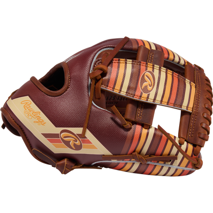 The Rawlings Heart of the Hide 11.75" Baseball Glove (PROR2175-13TI) features a brown design with tan, yellow, and orange striped accents on the webbing and thumb, plus visible Rawlings logos on the thumb and wrist strap.