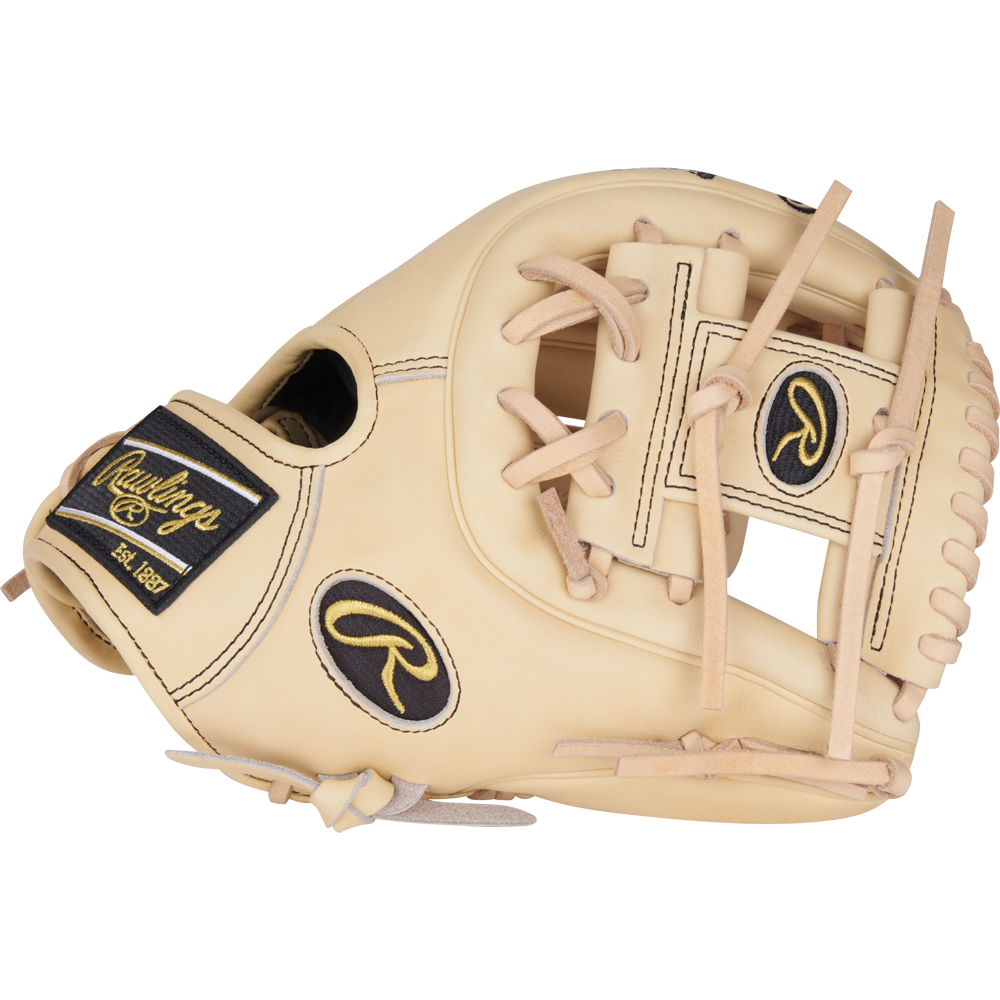 The Rawlings Heart of the Hide 11.25" Baseball Glove (PROR312-2CB) is a tan infield glove with black and gold accents, visible stitching, leather laces, a Pro-I web, and showcases detailed craftsmanship with signature brand patches.
